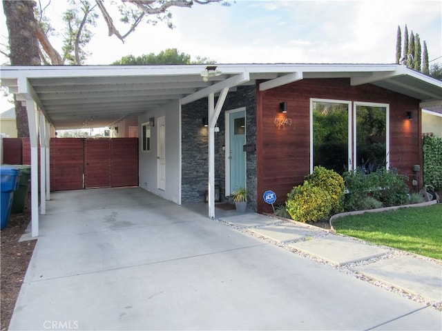 exterior space featuring concrete driveway and an attached carport