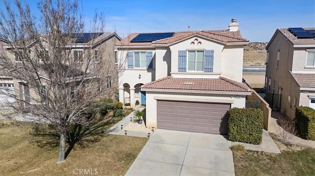 view of front of home featuring a garage, a front lawn, and solar panels