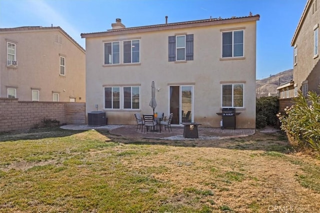 back of house featuring a yard, central AC unit, and a patio area