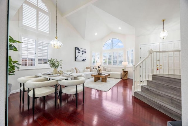 living room with a notable chandelier, dark wood-type flooring, and high vaulted ceiling