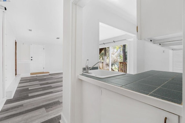 corridor with dark hardwood / wood-style flooring and sink