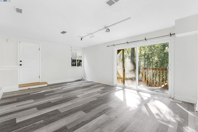 empty room featuring wood-type flooring and rail lighting