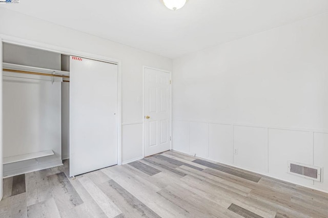 unfurnished bedroom with light hardwood / wood-style floors and a closet