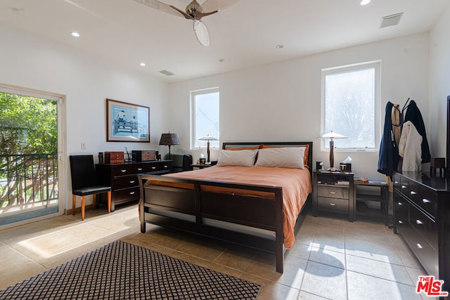 bedroom with multiple windows, light tile patterned flooring, and access to exterior