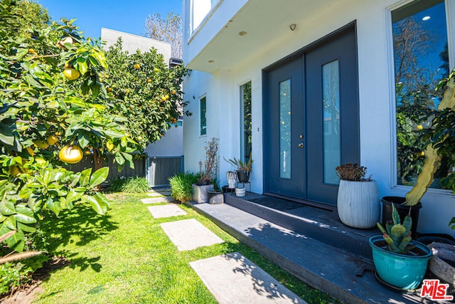 entrance to property featuring central AC and a yard