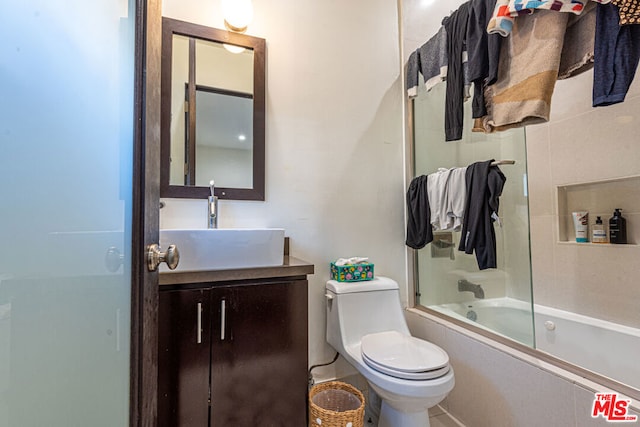 full bathroom with vanity, shower / bath combination with glass door, and toilet