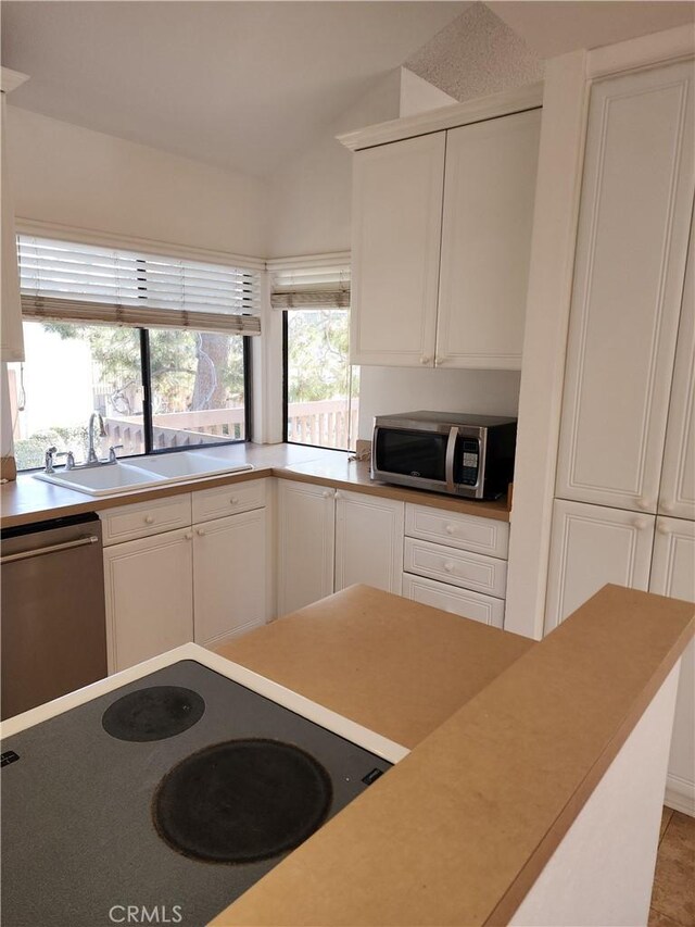 kitchen with stainless steel appliances, sink, and white cabinets