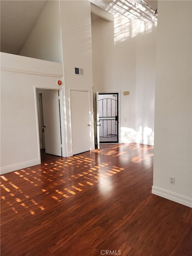 interior space featuring dark wood-type flooring and a high ceiling