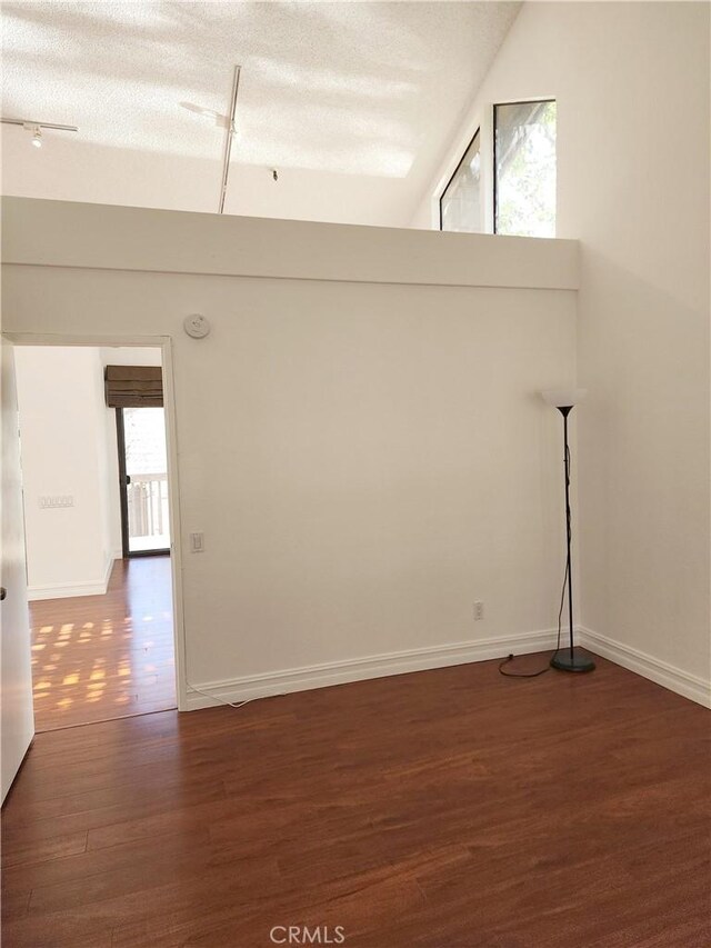 unfurnished room featuring dark wood-type flooring and a textured ceiling