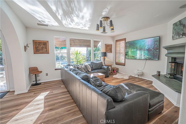 living room featuring a chandelier and light wood-type flooring