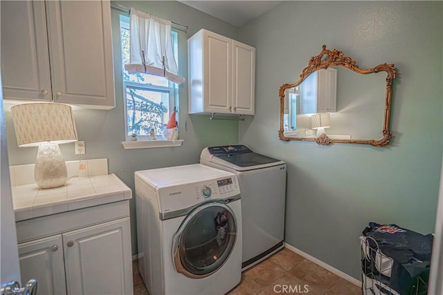 laundry area featuring cabinets, light tile patterned floors, and washing machine and clothes dryer