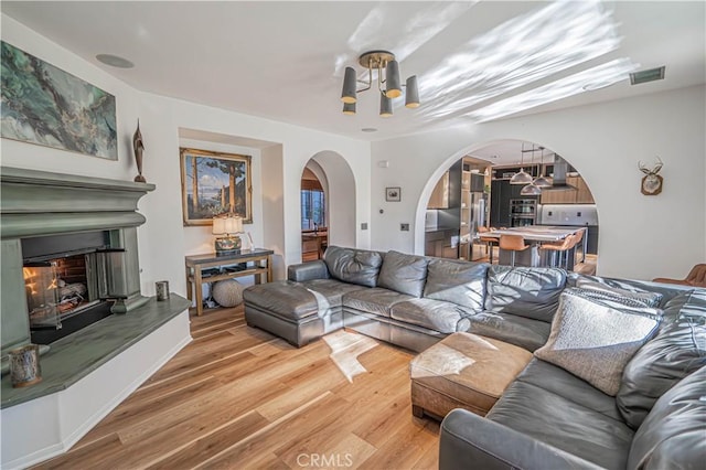 living room featuring wood-type flooring and a notable chandelier