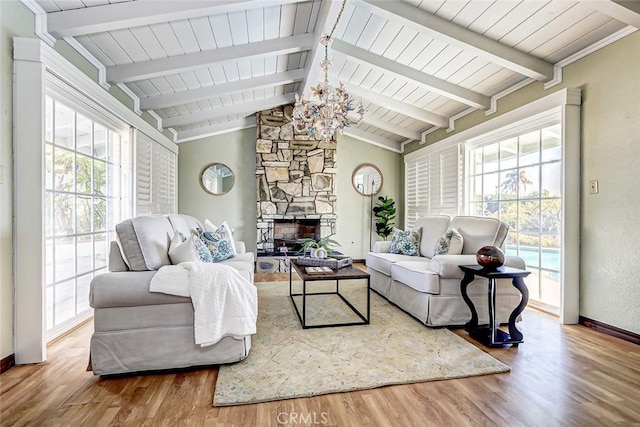 living room featuring plenty of natural light, a fireplace, hardwood / wood-style floors, and vaulted ceiling with beams