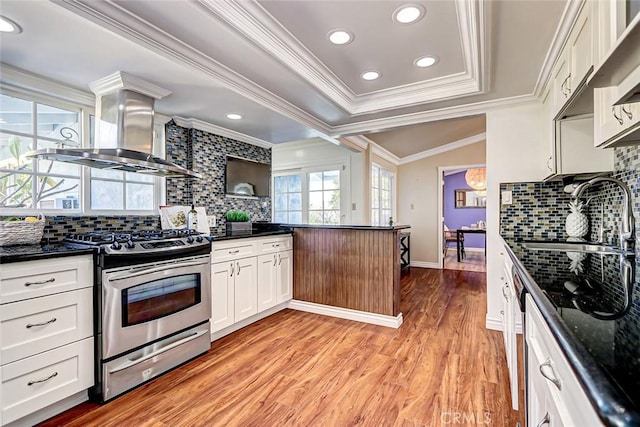 kitchen with island range hood, white cabinetry, sink, stainless steel gas range oven, and light hardwood / wood-style flooring