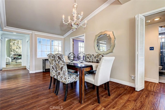 dining area featuring crown molding, vaulted ceiling, dark wood-type flooring, and a notable chandelier