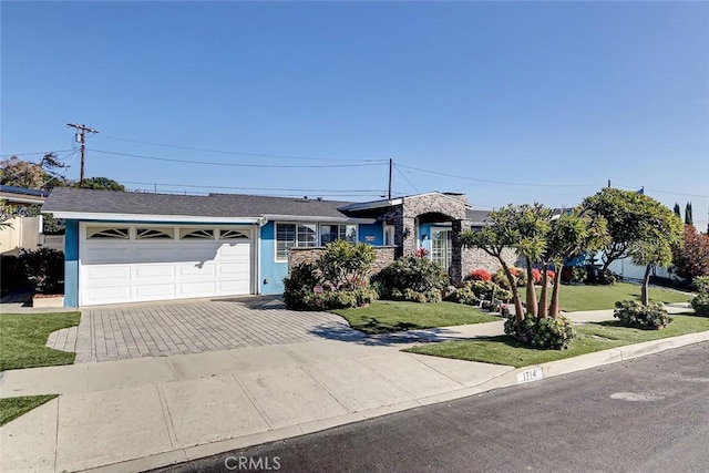 ranch-style house featuring a garage and a front lawn