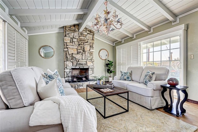 living room with wood-type flooring, a stone fireplace, vaulted ceiling with beams, and a notable chandelier