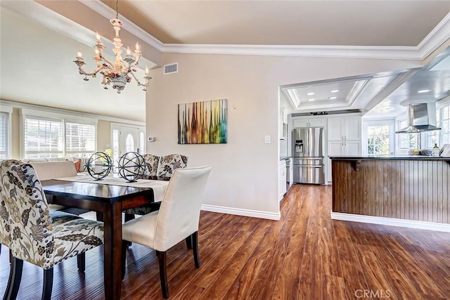 dining room with crown molding, vaulted ceiling, an inviting chandelier, and dark hardwood / wood-style flooring