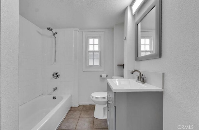 full bathroom featuring tile patterned flooring, tiled shower / bath combo, vanity, a textured ceiling, and toilet