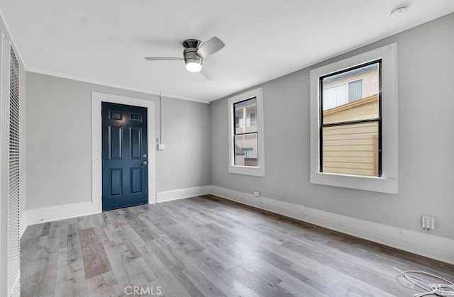 unfurnished room featuring crown molding, ceiling fan, light hardwood / wood-style flooring, and a wealth of natural light