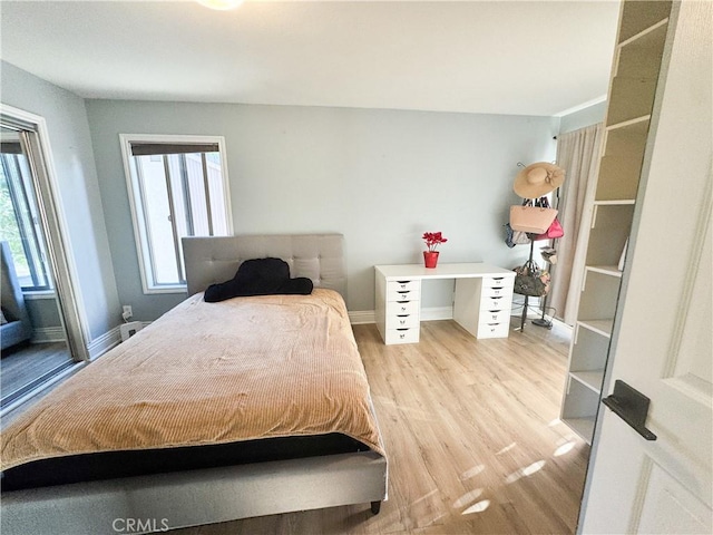 bedroom with multiple windows and light hardwood / wood-style flooring