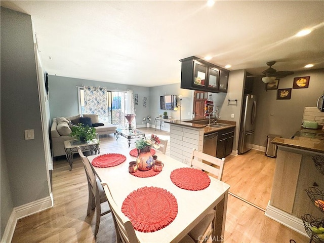 dining room featuring sink, ceiling fan, and light hardwood / wood-style flooring