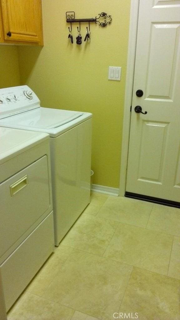 washroom with washer and dryer and cabinets