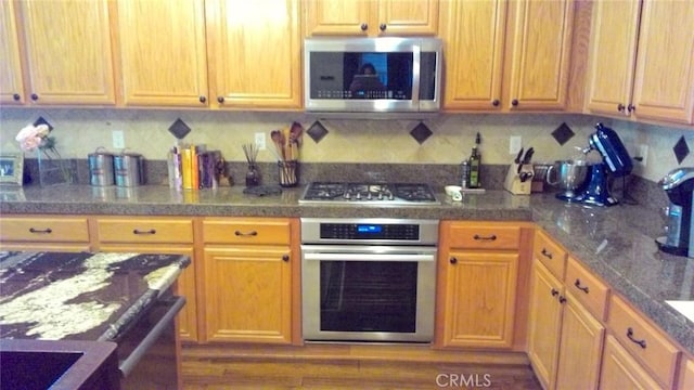 kitchen featuring appliances with stainless steel finishes and decorative backsplash