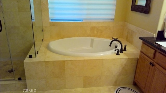 bathroom with vanity and shower with separate bathtub