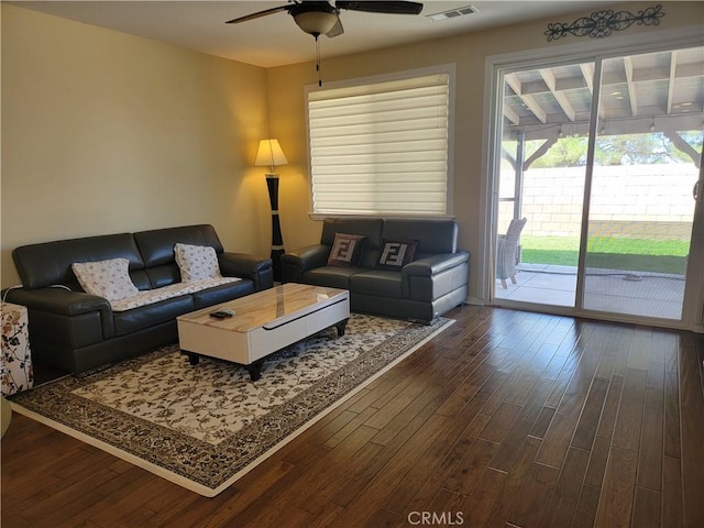 living room with ceiling fan and dark hardwood / wood-style flooring