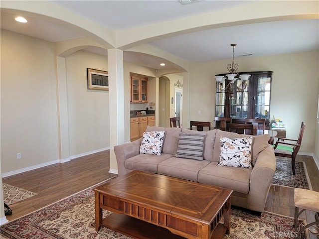 living room with dark wood-type flooring and a chandelier