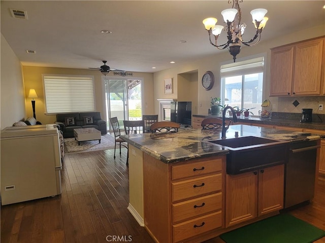 kitchen featuring dark hardwood / wood-style floors, sink, washer / dryer, and an island with sink