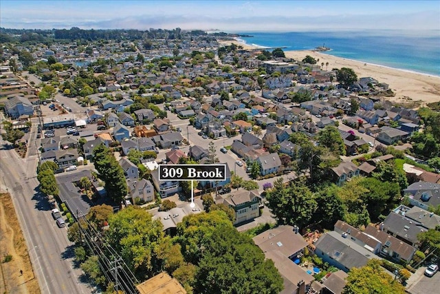 bird's eye view with a water view and a beach view