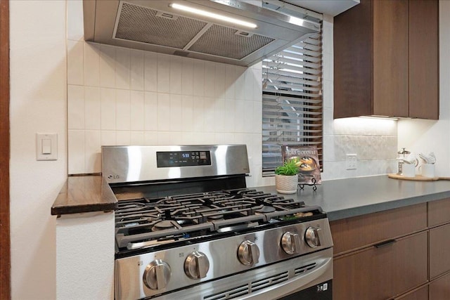 kitchen with tasteful backsplash, ventilation hood, and stainless steel range with gas stovetop