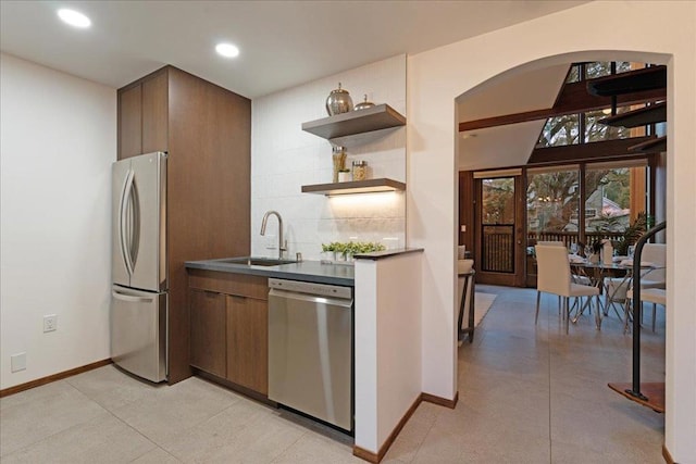 kitchen with appliances with stainless steel finishes, sink, and backsplash