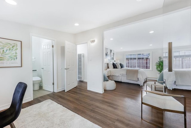 bedroom with dark hardwood / wood-style floors and ensuite bath