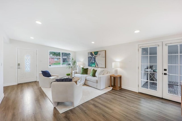 living room with light hardwood / wood-style flooring, french doors, and vaulted ceiling