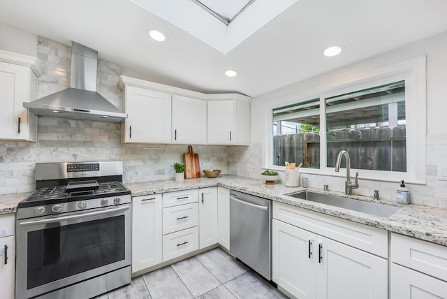 kitchen with sink, stainless steel appliances, white cabinets, and wall chimney exhaust hood