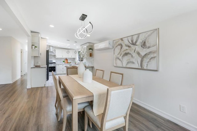 dining room with an inviting chandelier, a wall mounted air conditioner, and dark hardwood / wood-style floors