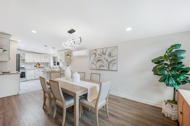 dining room featuring hardwood / wood-style flooring, an AC wall unit, and sink