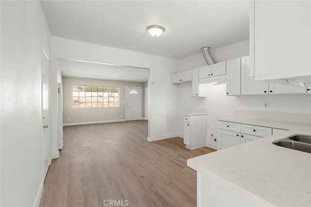 kitchen featuring white cabinetry, sink, and light hardwood / wood-style floors