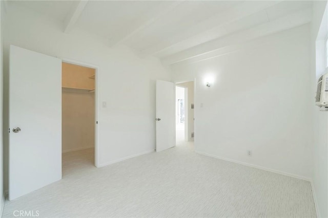 carpeted empty room with beam ceiling