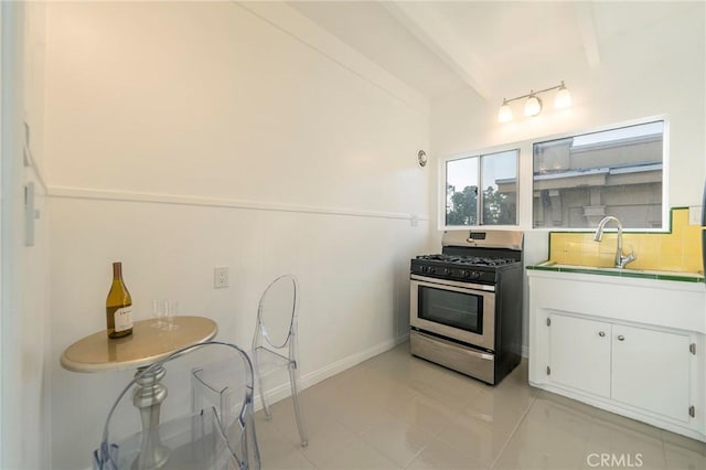 kitchen with beamed ceiling, white cabinetry, sink, decorative backsplash, and gas range