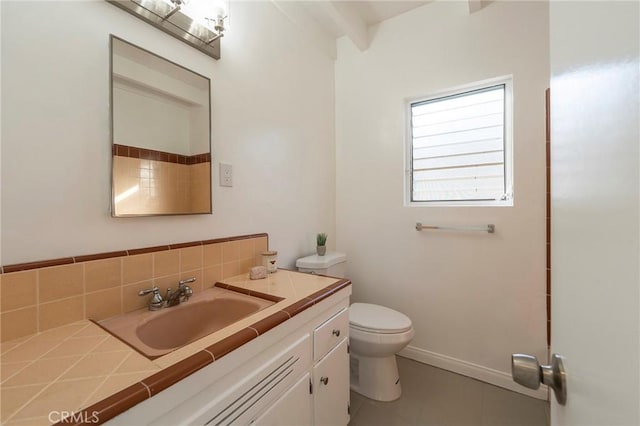 bathroom with vanity, toilet, and backsplash