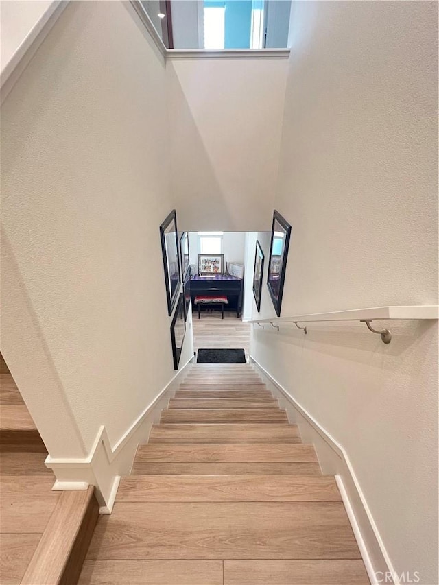 stairs featuring a healthy amount of sunlight and a towering ceiling