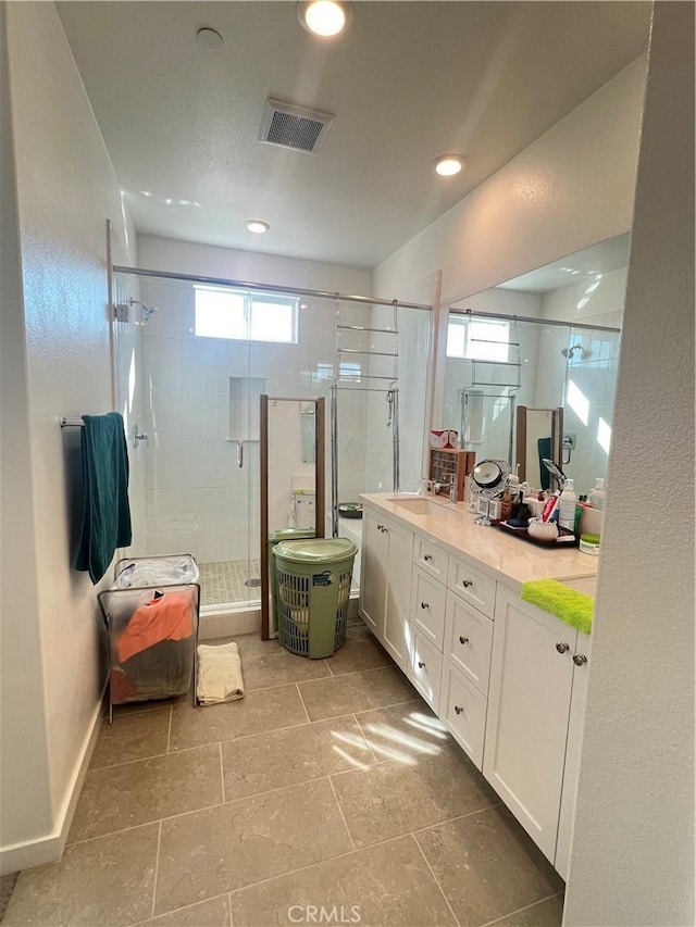 bathroom with plenty of natural light, a shower with door, and vanity