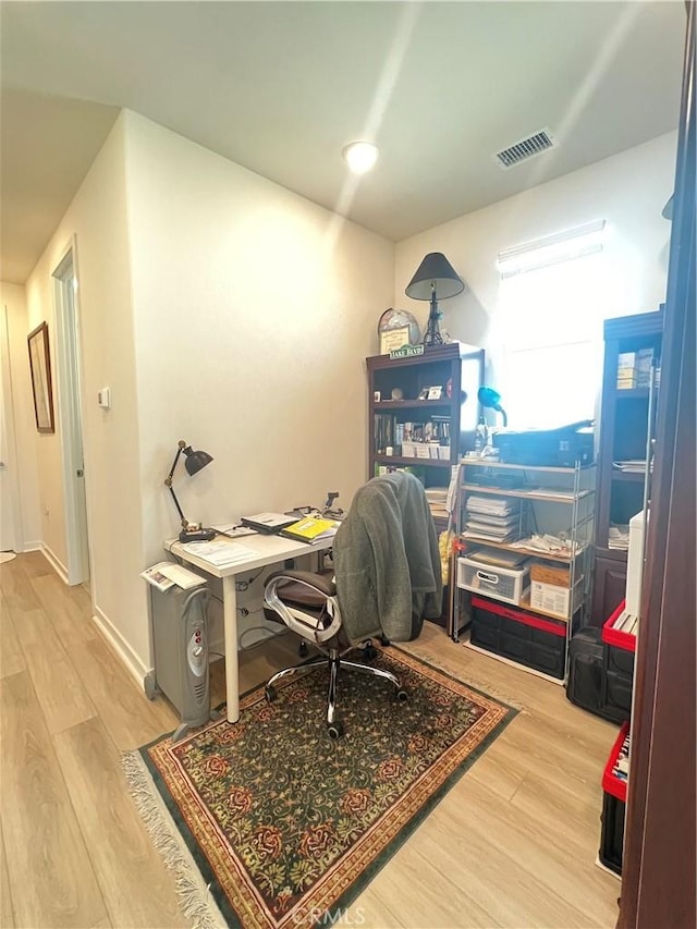 home office with light hardwood / wood-style flooring