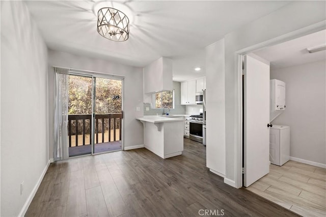 kitchen featuring sink, a breakfast bar, stainless steel appliances, wood-type flooring, and white cabinets