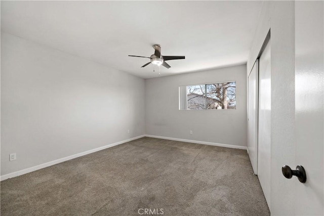 carpeted spare room with ceiling fan