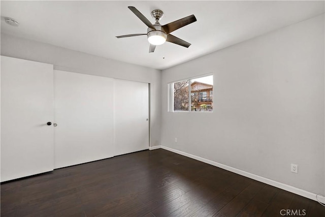 unfurnished bedroom featuring dark hardwood / wood-style flooring, a closet, and ceiling fan